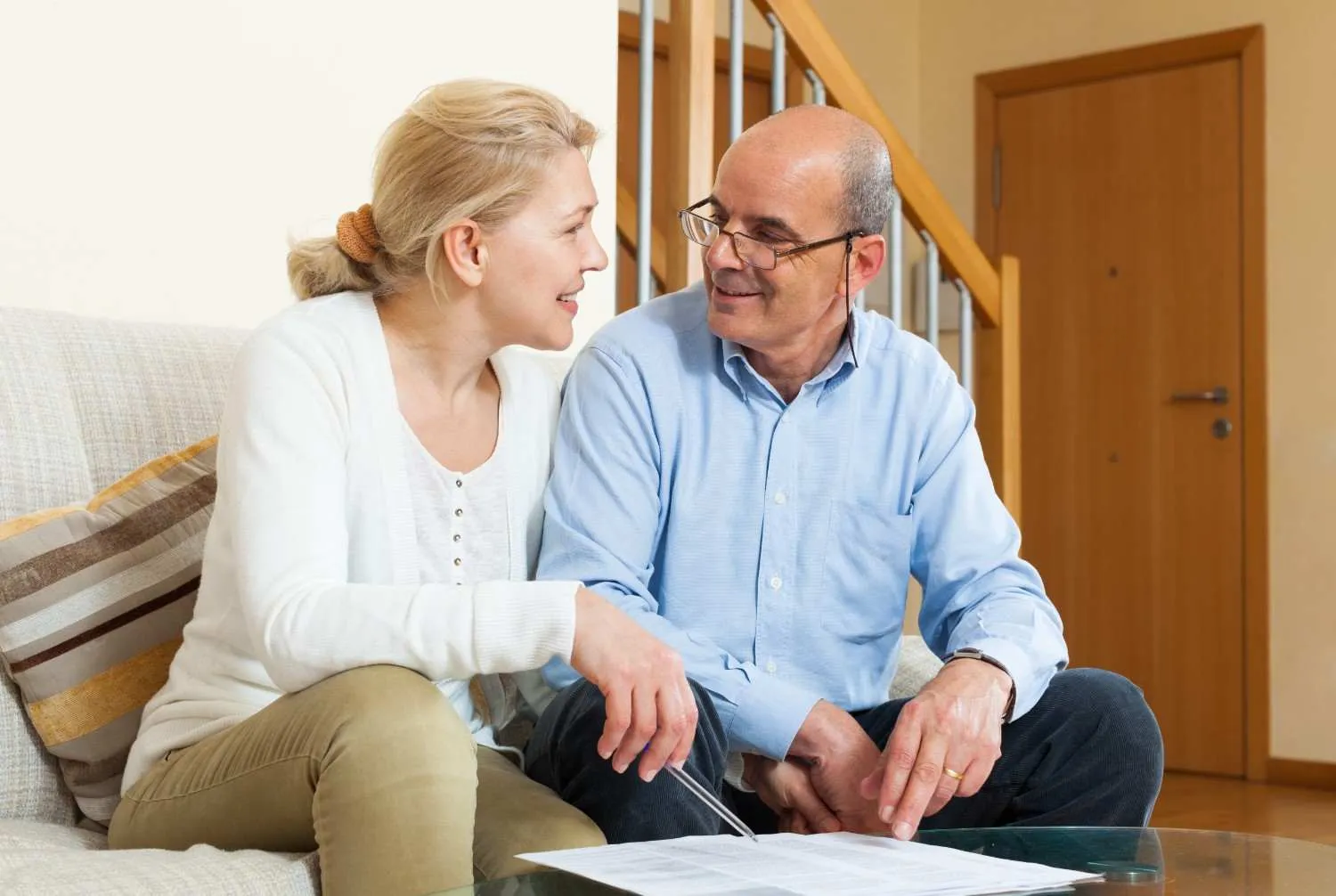 An older couple on a sofa going over their Medicare paperwork together